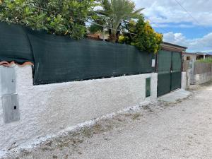 a fence with a green screen on top of it at Climbing House Chèrie Madeleine in Lido Di Fondi