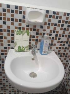 a bathroom sink with a bottle of soap on it at WARM Tourist Inn in Banhigan
