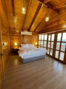 a bedroom with a large bed in a wooden room at اكواخ وشاليهات لوزان الريفية 2 in Dahaban
