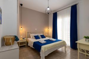 a bedroom with a bed with blue sheets and a window at Antigone View Apartments in Skala Potamias