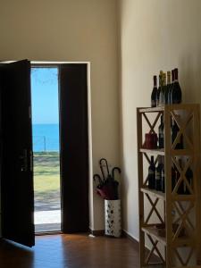 um quarto com uma porta e uma prateleira com garrafas de vinho em Oxygen Hotel em Shekhvetili