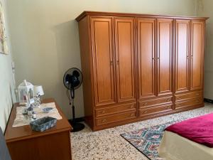 a bedroom with a large wooden cabinet and a table at Casa Gori in Montecatini Terme