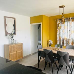 comedor con paredes amarillas, mesa y sillas en Peaceful apartment in Punta Cana, en Punta Cana