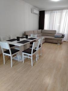 sala de estar con mesa, sillas y sofá en Apartments Sarafovo, en Burgas