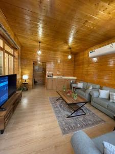 a large living room with a couch and a tv at اكواخ وشاليهات لوزان الريفية 2 in Dahaban