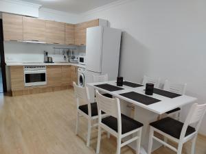 uma cozinha com uma mesa com cadeiras e um frigorífico em Apartments Sarafovo em Burgas