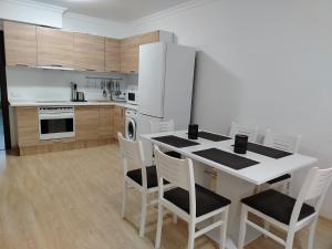 a kitchen with a table with chairs and a refrigerator at Apartments Sarafovo in Burgas City