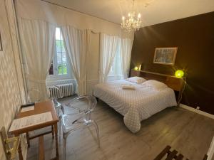 a bedroom with a bed and a chandelier at Hôtel Restaurant Le Beffroi in Salers +23 photos