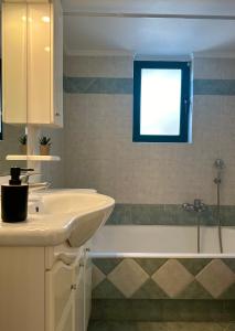 a bathroom with a sink and a bath tub at Saronida365 Sea & Sunset view in Saronida +29 photos