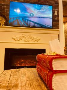 2 Bücher vor einem Kamin mit einem TV in der Unterkunft بيتي بلس للغرف الفندقية- مدخل مستقل in Riyadh Al Khabra