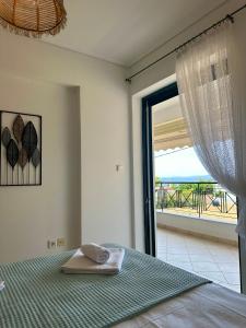 a bedroom with a bed with a view of the ocean at Saronida365 Sea & Sunset view in Saronida