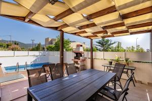 a patio with a wooden table and chairs on a roof at Petritis Villas B in Iraklitsa