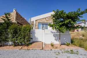 a house with a white gate and a tree at Petritis Villas B in Iraklitsa