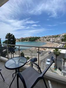 a balcony with a table and chairs and a view of a beach at Seafront Apartments in Ulcinj