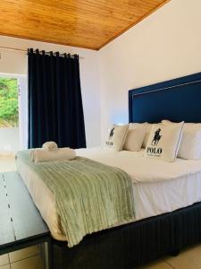 Schlafzimmer mit einem großen Bett mit blauem Kopfteil in der Unterkunft Ouklip Place Hotels in Roodepoort