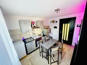 eine Küche mit einem Tisch und eine Küche mit rosa Lichtern in der Unterkunft Appartamento a Udine con doccia idromassaggio 