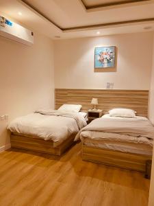 two twin beds in a room with at بيتي بلس للغرف الفندقية- مدخل مستقل in Riyadh Al Khabra