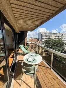 a patio with a table and chairs on a balcony at Large sunny and bright apartment with park view in Ostend