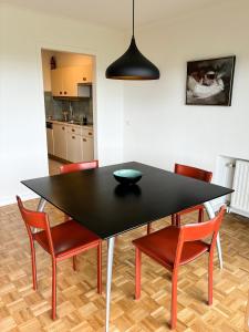 a black dining room table with chairs and a bowl on it at Large sunny and bright apartment with park view in Ostend +23 photos