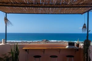 - une vue sur la plage depuis le balcon d'une maison dans l'établissement Monkey's Guest House - Appartement roof top terrasse privée vue sur mer, à Tamraght Ouzdar