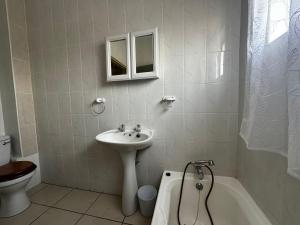 Un baño con lavabo, inodoro y bañera. en Ipanema 3, en Margate