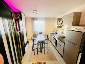 a kitchen with a table and chairs and a refrigerator at Appartamento a Udine con doccia idromassaggio 