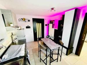 een keuken met een tafel en een keuken met roze verlichting bij Appartamento a Udine con doccia idromassaggio 