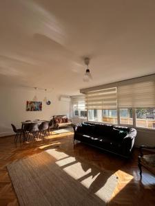 a living room with a black couch and a table at Green Garden View Apartment Near Zorlu Center in Istanbul