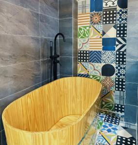 胡志明市的住宿－Secret Elm Hotel，浴室设有木浴缸,铺着瓷砖