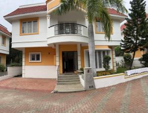 a house with a palm tree in front of it at Bay view in Mahabalipuram