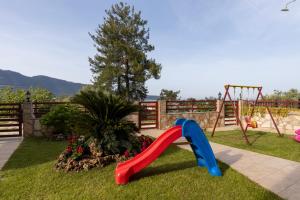 a playground with a red and blue slide at Antigone View Apartments in Skala Potamias