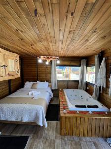 a bedroom with two beds in a wooden room at Chalés Refúgio Ohana in Urubici