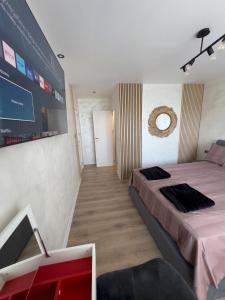 a bedroom with a large bed and a tv at SeaView Lazur Apartment in Burgas City