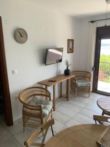 a living room with a television and a table and chairs at apartment by the sea in Neos Marmaras