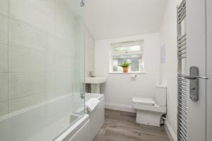 a bathroom with a tub and a toilet and a sink at Vale House By EDEN Accommodation - 2 Bedroom Whole House, Sleeps 4 - NEWLY RENOVATED in Kettering