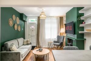 a living room with green walls and a couch at Vale House By EDEN Accommodation - 2 Bedroom Whole House, Sleeps 4 - NEWLY RENOVATED in Kettering