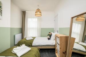 a bedroom with two beds and a mirror at Vale House By EDEN Accommodation - 2 Bedroom Whole House, Sleeps 4 - NEWLY RENOVATED in Kettering
