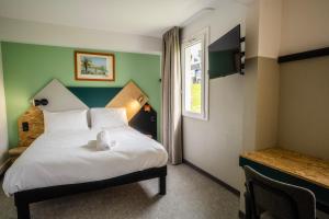 a bedroom with a white bed with a window at greet Hôtel Montbéliard in Montbéliard