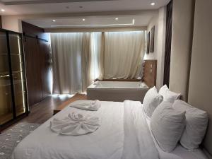 1 dormitorio con cama blanca y bañera en The Palace Pyramids Hotel en El Cairo