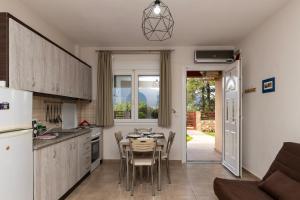 a kitchen with a table and chairs and a kitchen with a refrigerator at Antigone View Apartments in Skala Potamias