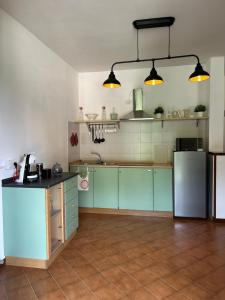 a kitchen with green and blue cabinets and appliances at Bellagio Neighbor Apartment in Limonta
