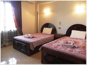 a bedroom with two beds and a window at Nile Dream Apartments in Luxor