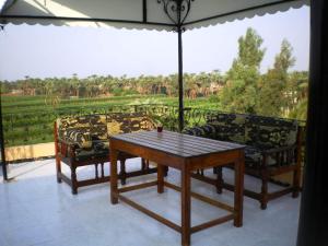 a living room with a table and chairs on a balcony at Nile Dream Apartments in Luxor