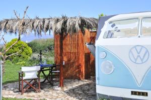 un furgone bianco e blu parcheggiato accanto a un tavolo di Magic Bus a Kíssamos