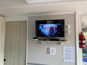 einen Flachbild-TV an der Wand in einem Zimmer in der Unterkunft Mobil-home Confort TV CLIM Narbonne-Plage in Narbonne-Plage