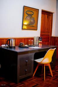 escritorio con silla amarilla en una habitación en L'anis Etoilé en Antsirabe