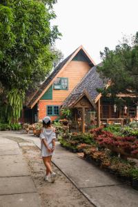 a woman is standing in front of a building at Ban MaeBo Local Stay in Ban Nong Han