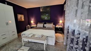 - une chambre avec un lit blanc et des murs violets dans l'établissement Studio apartman Marta, à Korenica