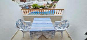 een blauwe en witte tafel en stoelen op een balkon bij Los Geranios in Adeje