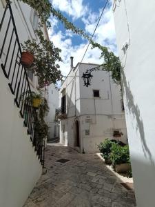 un vicolo con un edificio bianco con un balcone di Dimora Nuccio a Martina Franca